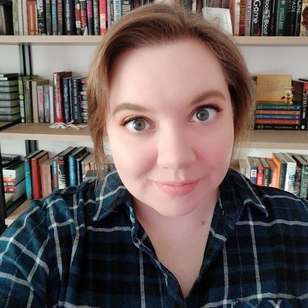 Photograph Rachel Stockbridge smiling in front of a bookcase